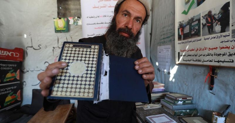 مسنّ فلسطيني يرمم مصاحف متضررة عُثر عليها بين أنقاض غزة