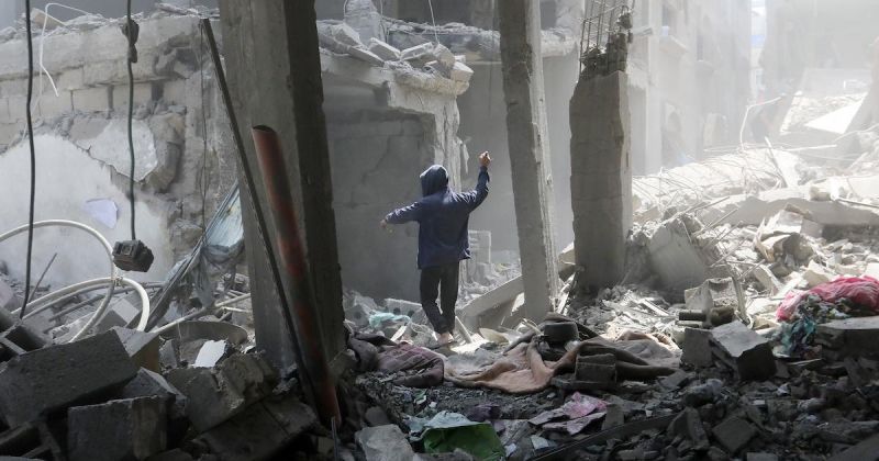 فلسطينيون يتفقدون المباني المتضررة عقب غارة جوية إسرائيلية على مخيم الشاطئ