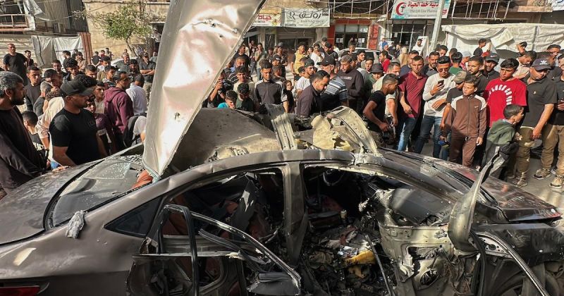 فلسطينيون يتجمعون في موقع غارة إسرائيلية استهدفت مركبة في مدينة غزة