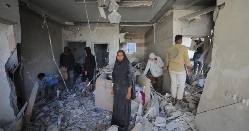 فلسطينيون يتفقدون ما تبقى من منازلهم بعد غارة إسرائيلية على مخيم المغازي