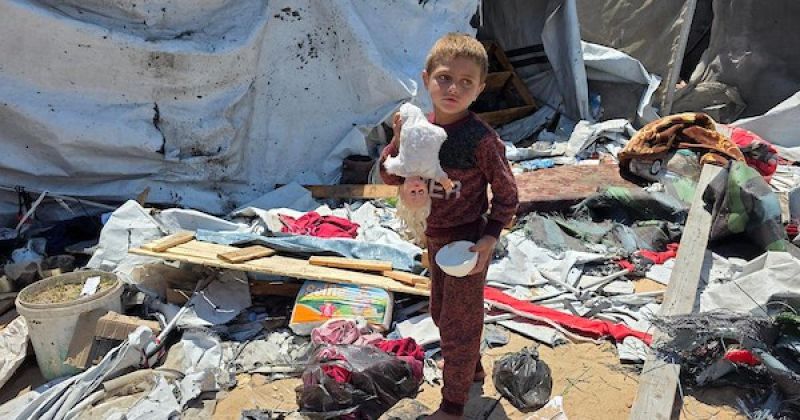 فلسطينيون يتفقدون خيمة متضررة لعائلة نازحة عقب غارة إسرائيلية