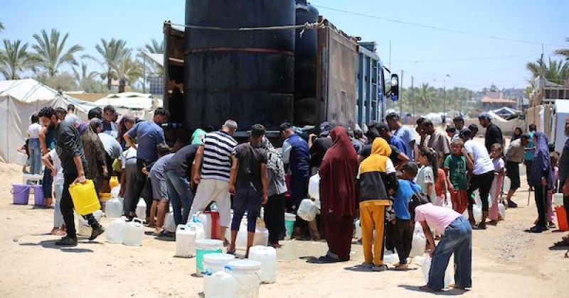 نساء وأطفال فلسطينيون يصطفون للحصول على مياه الشرب في منطقة الزوايدة