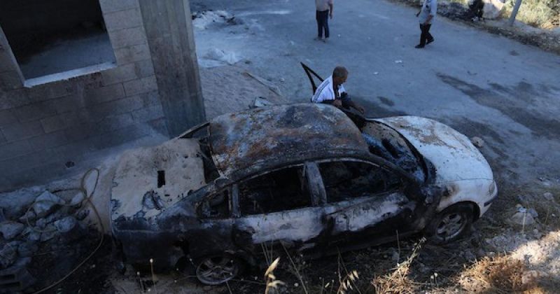 فلسطينيون يتفقدون منزلاً ومركبة محترقين عقب هجوم شنه مستوطنون في نابلس