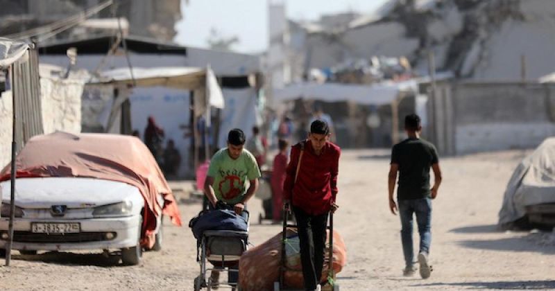 نازحون يحملون أمتعتهم أثناء مغادرتهم خيامهم في حي الزيتون بمدينة غزة