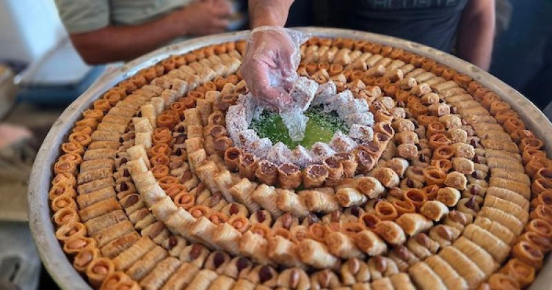 فلسطينيون يشترون الحلوى من متجر محلي عقب إعلان نتائج امتحانات التوجيهي في خان يونس